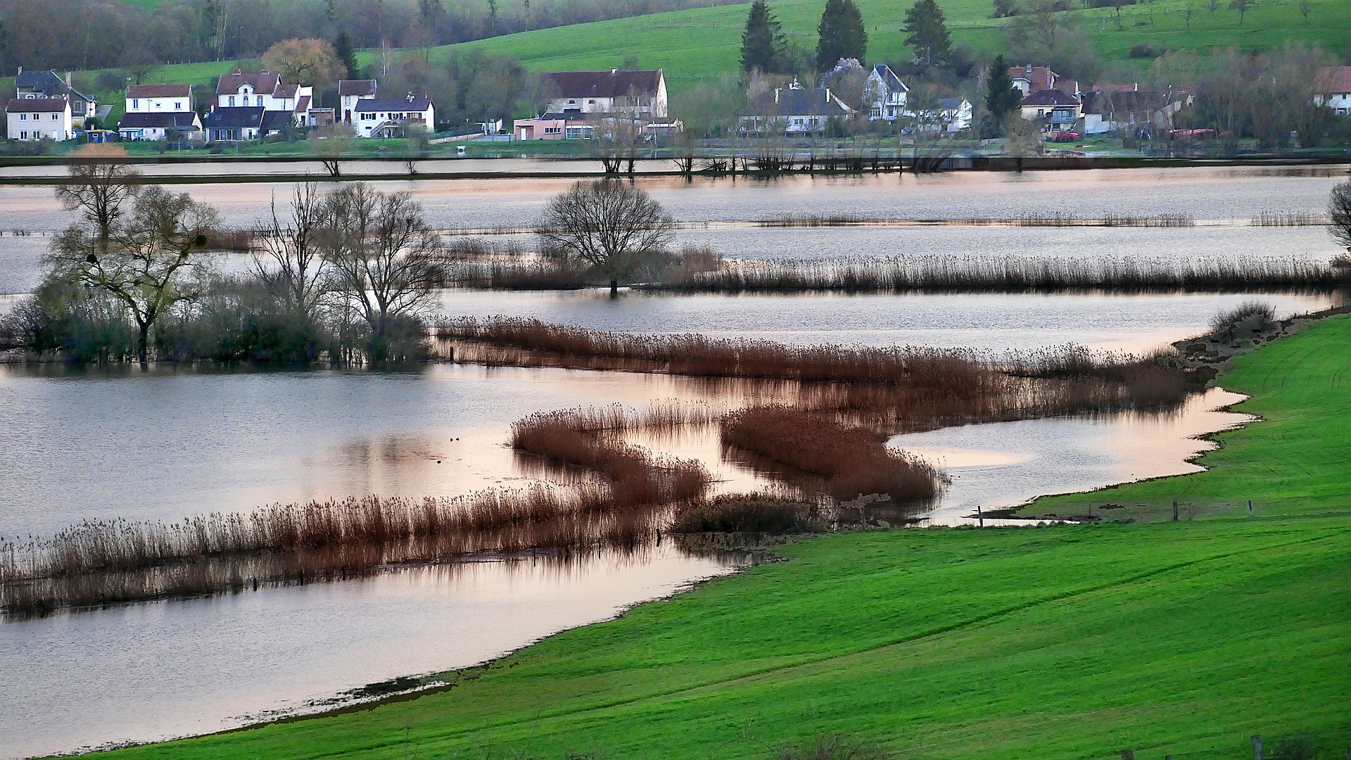 photo inondation - eau sur des champs, village au fond