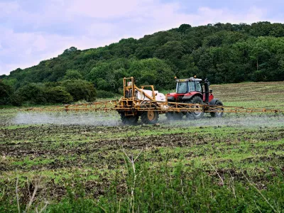 Tracteur en train d'épandre des pesticides sur un champ - source pixabay